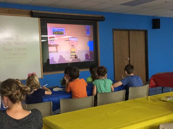 group of kids in the community room at NPL watching cartoons