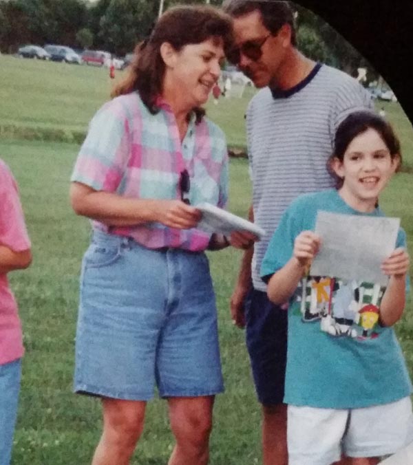 image of Mary Pat Behrens and her parents at a summer library program in 1996