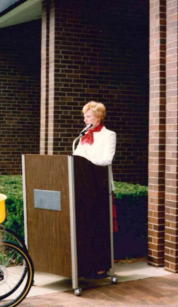 image of joan speking at a podium outside Normal Public Library